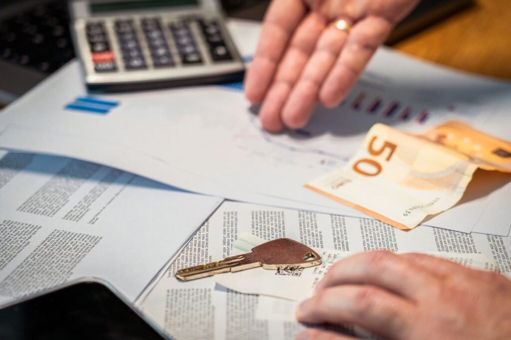 Clé de voiture, billets et calculatrice sur un contrat