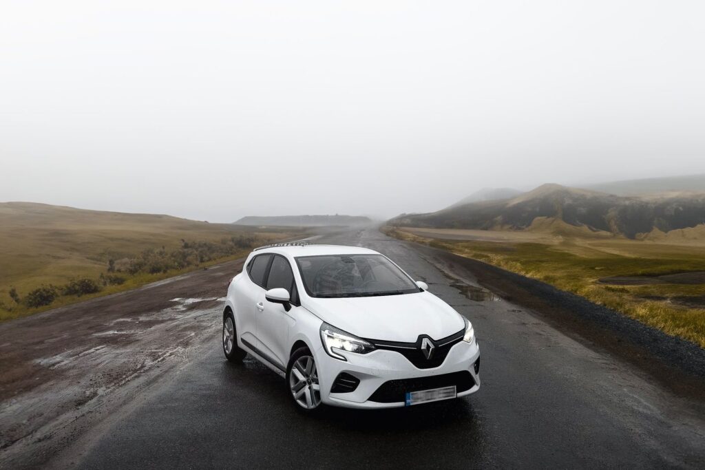 Renault Clio blanche sur une route de campagne