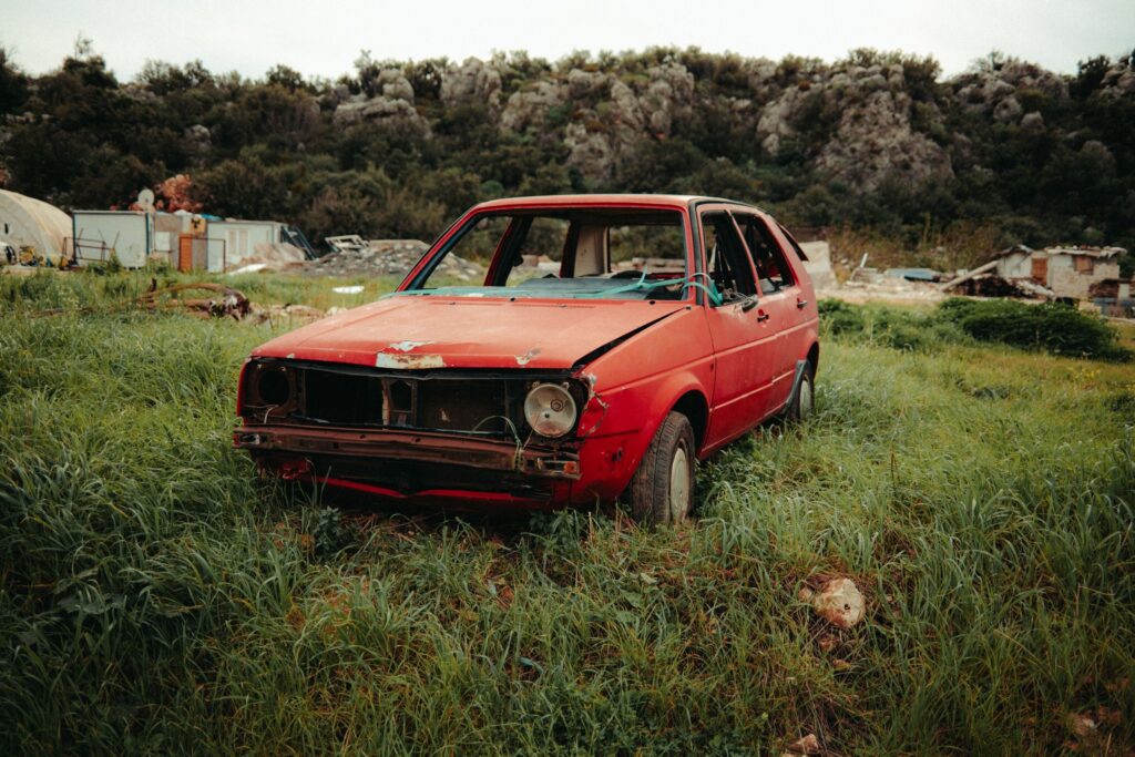 Voiture hors d'usage abandonnée dans un terrain en friche